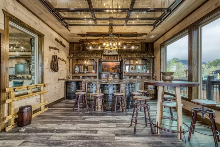 Rustic Luxury Cabin Bar in Sevierville, TN. Crafted wooden interior with a modern glass garage-style door and Southern decor details, offering mountain views.