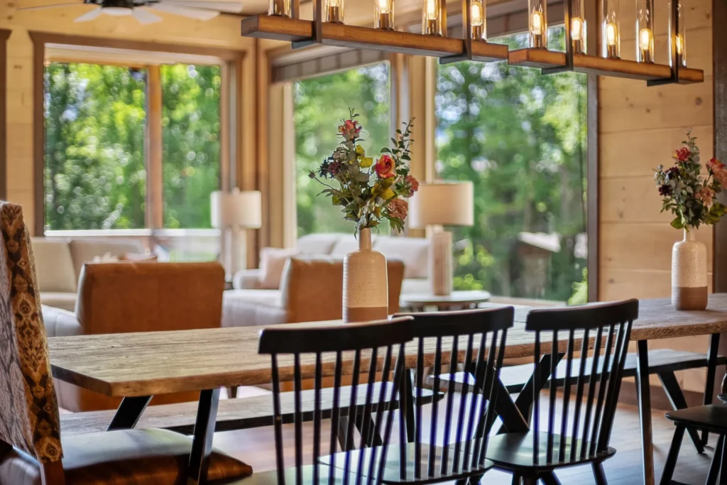 Side view of a custom-designed MCHB bar table in a luxury Pigeon Forge cabin. Features a multifunctional wooden surface used for dining, coffee, or a home office workspace with mountain views.