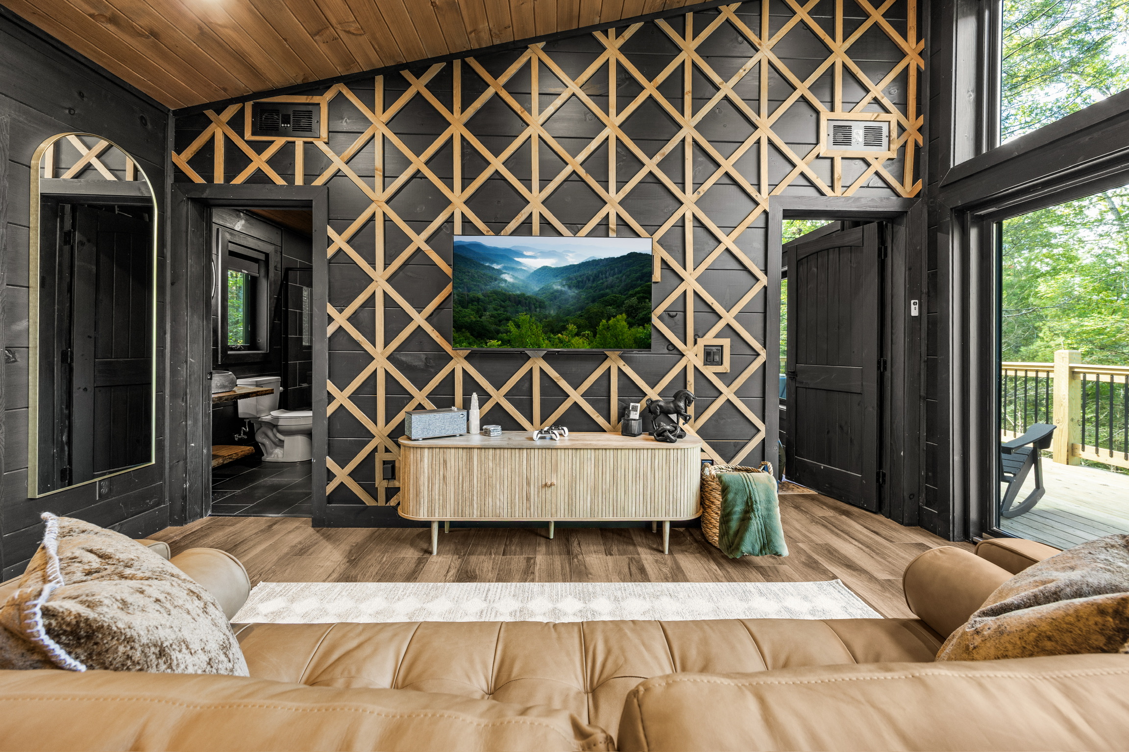 View of Living room area showing high-end appliances, sophisticated interior design walls, and selected, exquisite ornaments in a luxury cabin mountain home in the Smoky Mountain, Gatlinburg, Pigeon Forge, Sevierville, Tennessee region. Built with All Inclusive building services from lot to turnkey, ideal for rental, investment, vacation, mountain living, asset for generations. Contemporary designed cabins.