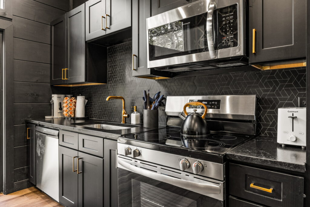 Modern Luxury Cabin Kitchen with high-end appliances, black cabinetry, and marble countertops, East TN.
