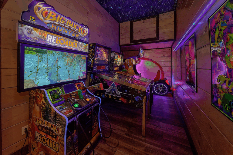 Luxury Mountain Home In-House Arcade video game room. Features pinball and multiple arcade machines, neon lighting, and stylized ceiling. Fully loaded custom entertainment, Smoky Mountains TN.