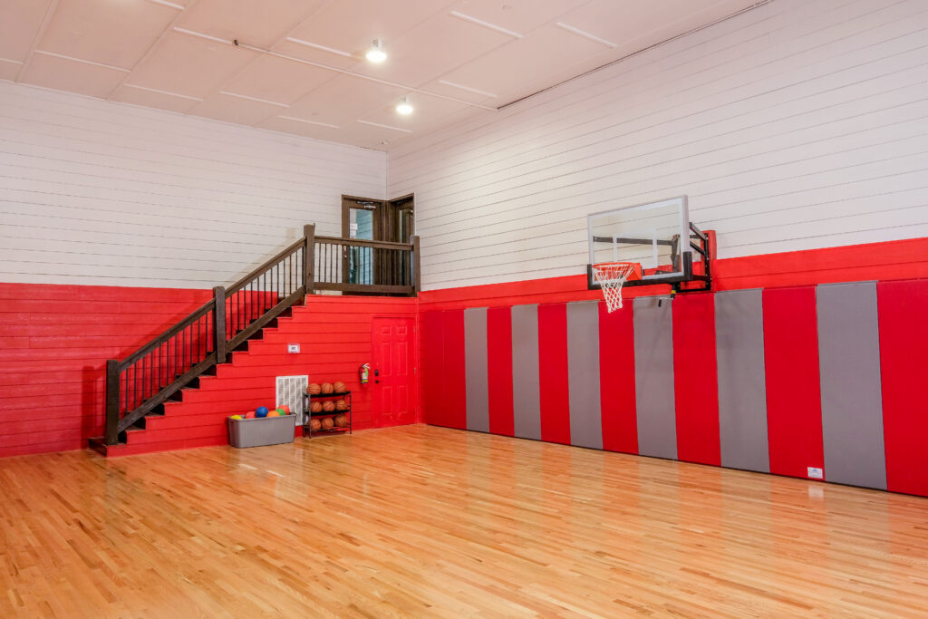 Luxury Mountain Home Indoor Multi-Sports Court with professional-grade floor and basketball hoop. Ample space for volleyball, indoor soccer, yoga, and more, in the Smoky Mountains, TN.