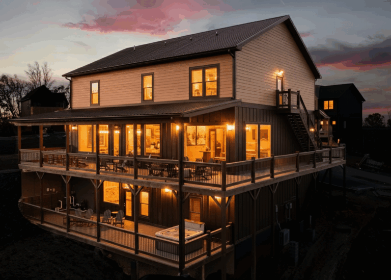 uxury mountain home exterior at an autumn sunset in the Smoky Mountains. Features a glowing interior and custom engineering by MCHB in East Tennessee.