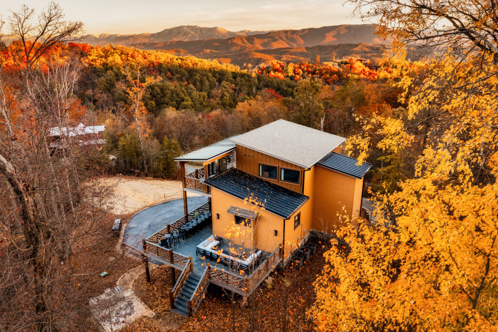 Aerial view of Mountaineer Trail: Summit Skies, a contemporary three-story luxury mountain home by MCHB. Surrounded by lush Smoky Mountain landscape and autumn foliage in Sevierville, East TN.