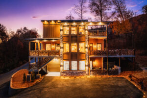 Front exterior of a luxury three-level mountain home by MCHB in the Smoky Mountains. Featuring custom architecture, multiple decks, and high-end amenities in a premium Sevierville, TN cabin.