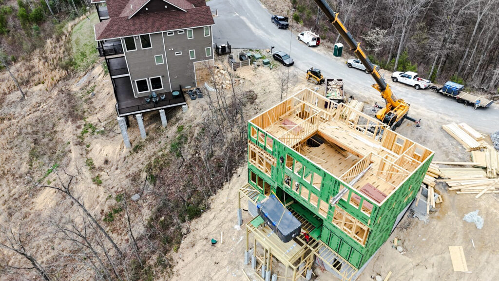Crane lifting a 16-foot swim spa at 3098 Smoky Bluff Trail, Sevierville, TN. Part of an MCHB luxury cabin installation on a steep mountain slope.