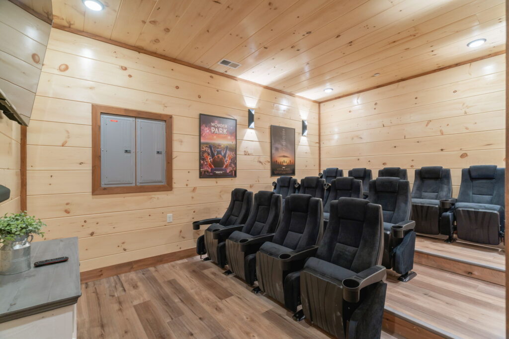 Luxury home theater room inside Shell Mountain Sunrise. Features tiered seating, large screen, and modern acoustic design in an MCHB custom cabin in the Smoky Mountains.