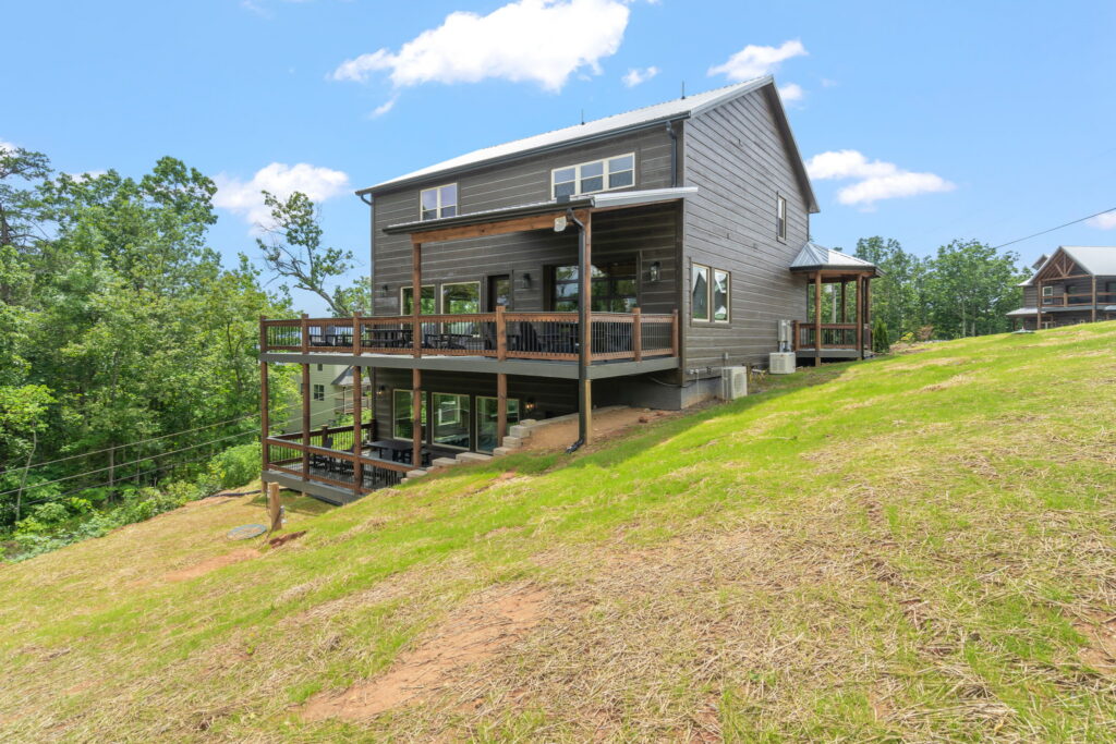 side exterior profile of Shell Mountain Sunrise, a 4,800 sq. ft. luxury MCHB cabin. Showcases multi-level balconies and the engineering precision required to build "flawlessly" on steep Smoky Mountain terrain near Sevierville, TN.