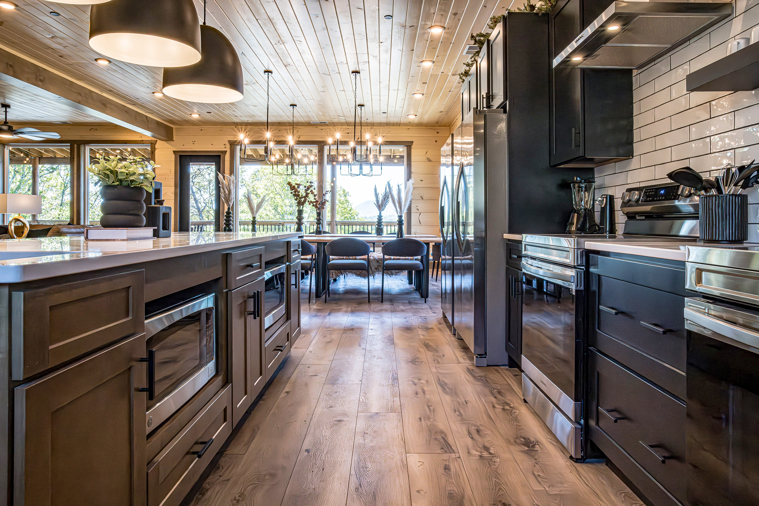 Leading line artistic view of a luxury MCHB mountain kitchen in Sevierville, TN, showing high-end appliances and the dining area.