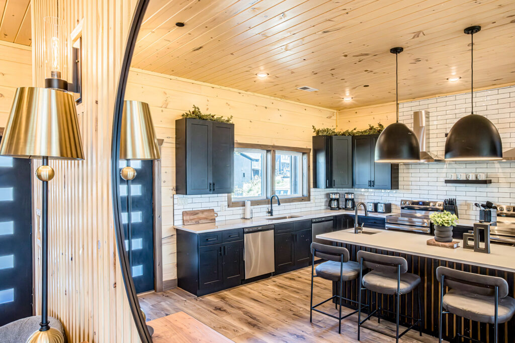 Mirror reflection showing a luxury kitchen sink and breakfast bar in a contemporary mountain home.