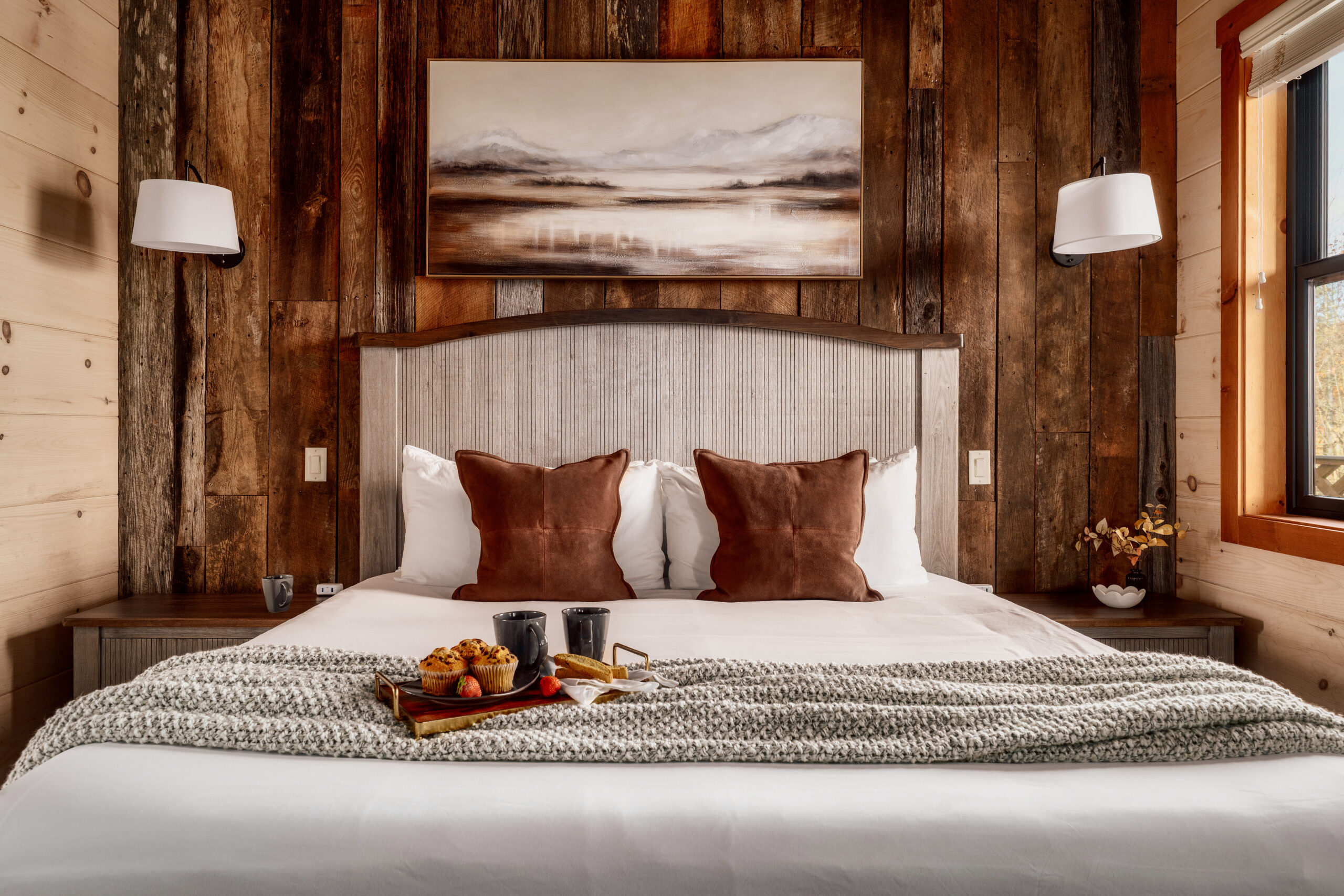 MCHB modern-classic luxury bedroom in Gatlinburg, TN. Features rich wooden walls, custom-made furniture, exquisite linens, and warm, integrated lighting in a Smoky Mountain cabin.