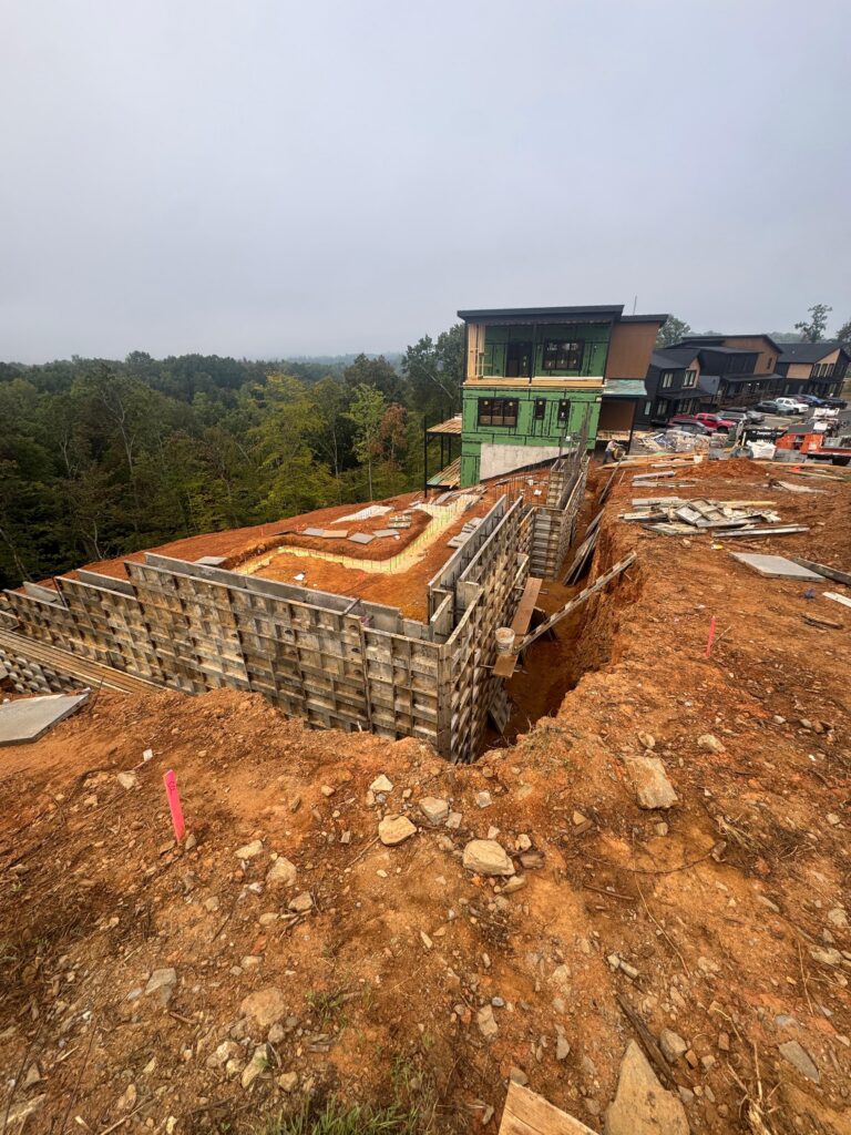 Detailed view of a mountain home worksite in Gatlinburg, TN, showing strategic drainage planning and land positioning for long-term stability. Detailed view of a mountain home worksite in Gatlinburg, TN, showing strategic drainage planning and land positioning for long-term stability.