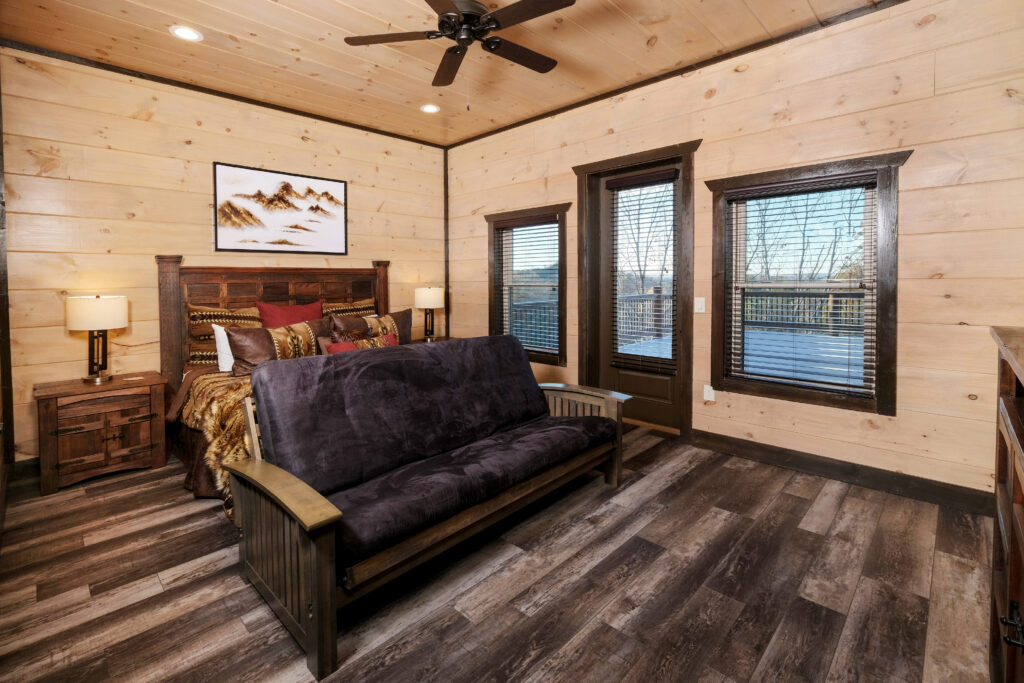 MCHB luxury classic mountain home bedroom in Pigeon Forge, TN. Features comfortable custom-made furniture and an integrated cozy couch in a junior suite setting with rich woodwork.