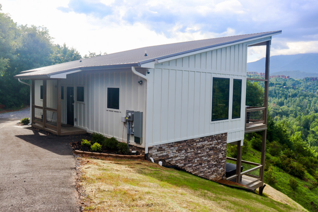 Modern mini-cabin adapted to steep sloped mountain terrain, maximizing footprint efficiency and natural views.