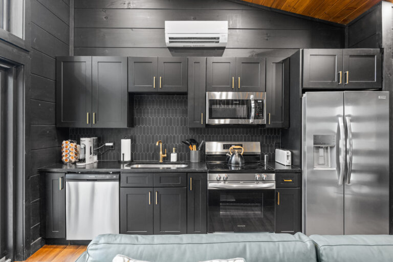 Detail of a luxury mini cabin kitchen in Pigeon Forge, fully equipped with high-end stove, dishwasher, and integrated refrigerator.