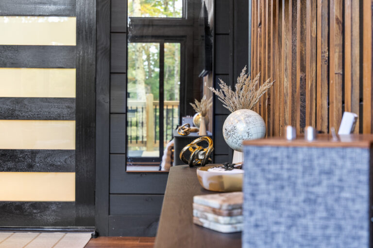 Inside view of a mini cabin entrance in Sevierville, showing minimal ornaments and an elegant wireless Bluetooth speaker.