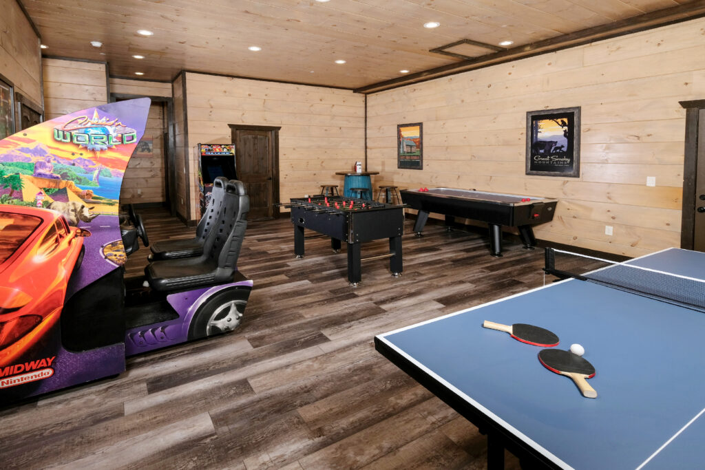 Custom arcade-game room inside a Sevierville luxury cabin, featuring a mix of classic and modern gaming machines in a climate-controlled space.