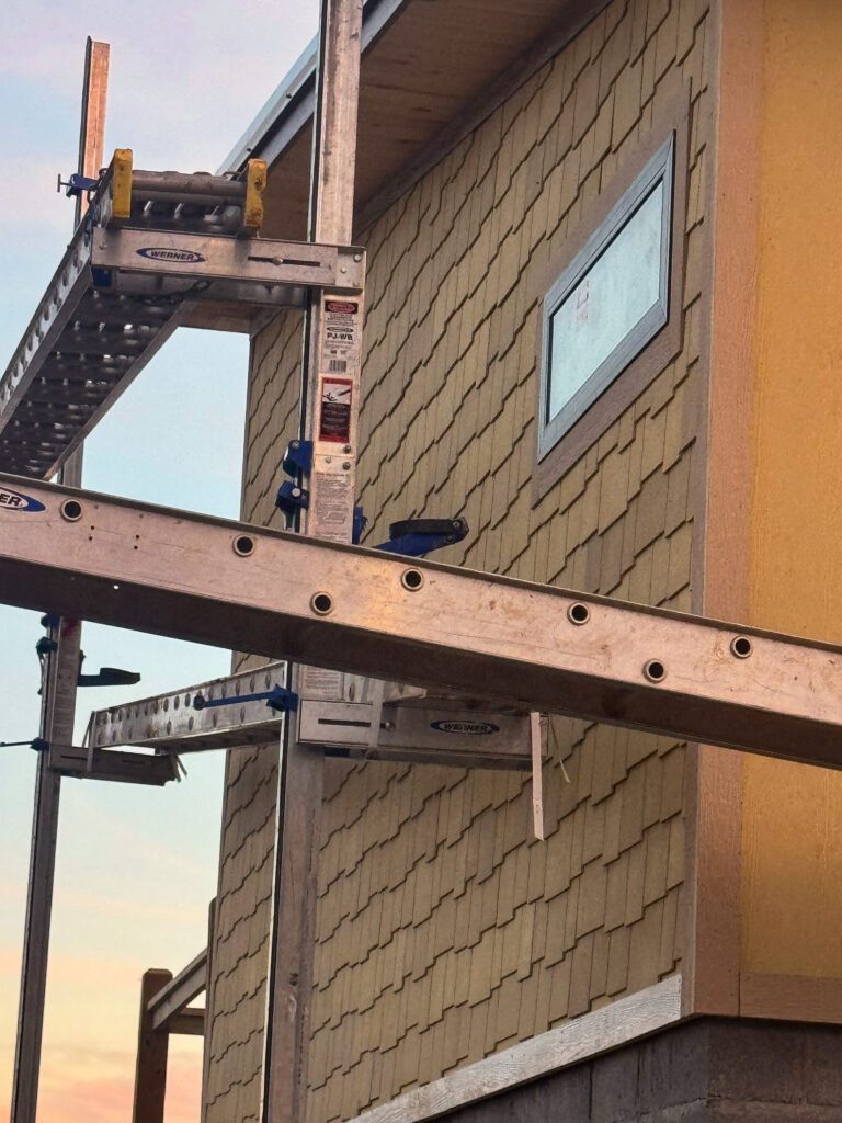 Detailed close-up shot of custom exterior wall construction and high-performance window flashing installation on a mountain home by MCHB.