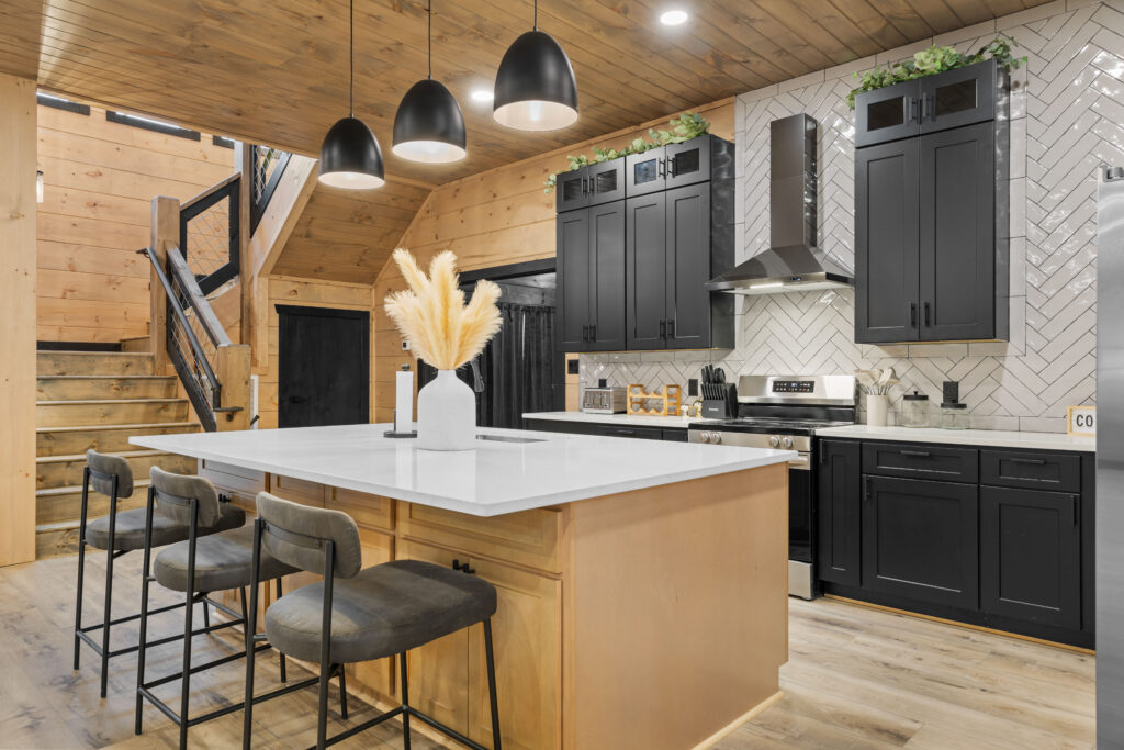 Side view of a sleek minimalist kitchen showcasing modern tile backsplash, high-end stainless range, built-in extractor hood, and custom cabinetry in Sevierville
