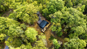 Overhead aerial drone view looking straight down at a custom mountain cabin nestled deep within a dense, green forest canopy in Gatlinburg TN