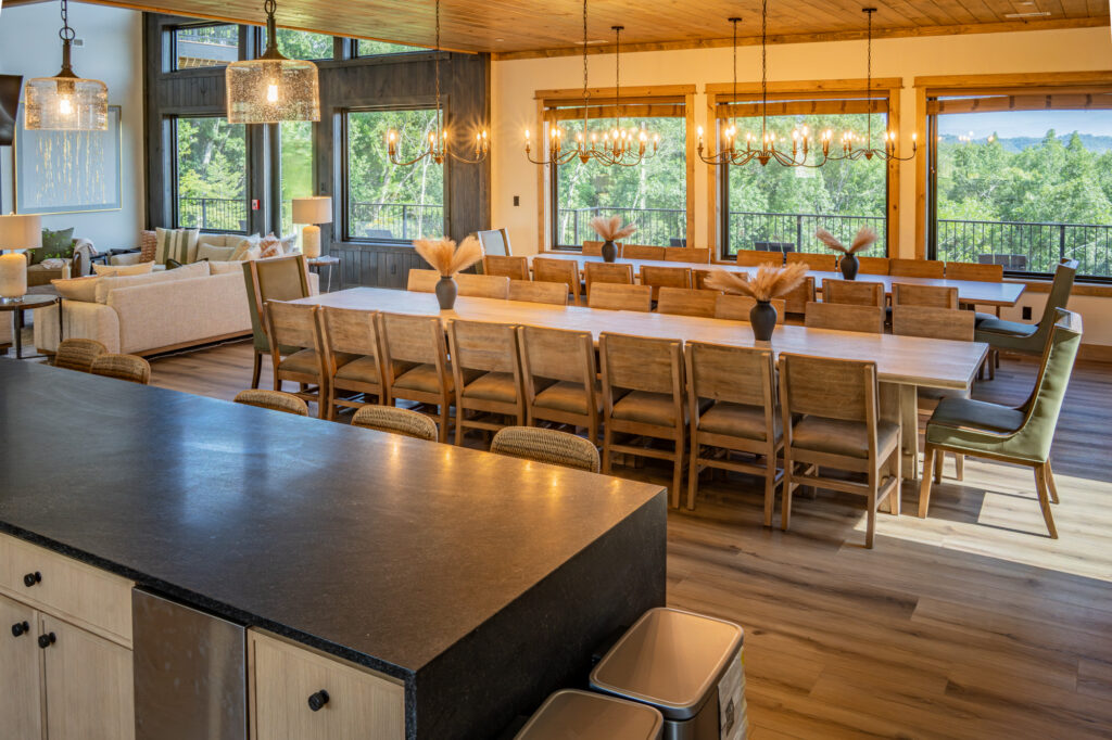 View from the kitchen island showing open-concept sightlines connecting the kitchen, formal dining area, and main living room in a luxury Gatlinburg home